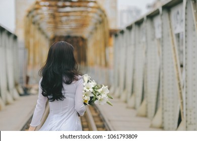 The girl in traditional Vietnamese dress with lily flowers ( Hoa loa Ken ) in April every year in Hanoi, Vietnam