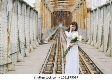 The girl in traditional Vietnamese dress with lily flowers in April every year in Hanoi, Vietnam.