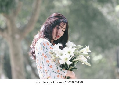The girl in traditional Vietnamese dress with lily flowers in April every year in Hanoi, Vietnam.