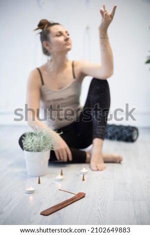 girl training in yoga studio.  Healthy and fly Yoga Concept. studio atmosphere - happy smiling girl and incense sticks with candles in the foreground
