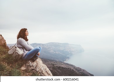 Girl travel in mountains alone. Spring weather, calm scene. Backpacker walking outdoors, back view over landscape. Wanderlust photo series.