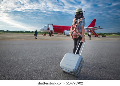Girl traveler with luggage going to plane