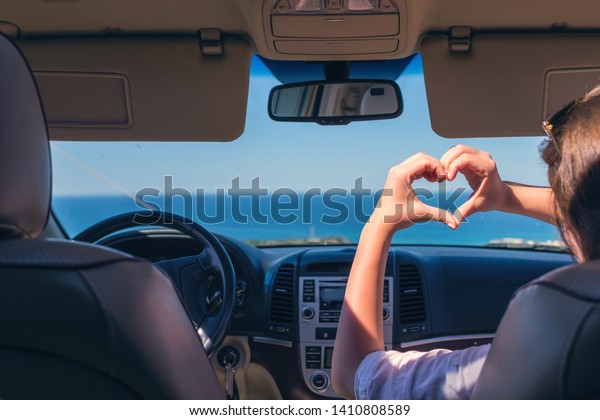 girl traveling by car on the\
Italy and holds her hands in the form of heart. Travel love\
symbol.