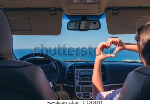 girl traveling by car on the\
Italy and holds her hands in the form of heart. Travel love\
symbol.