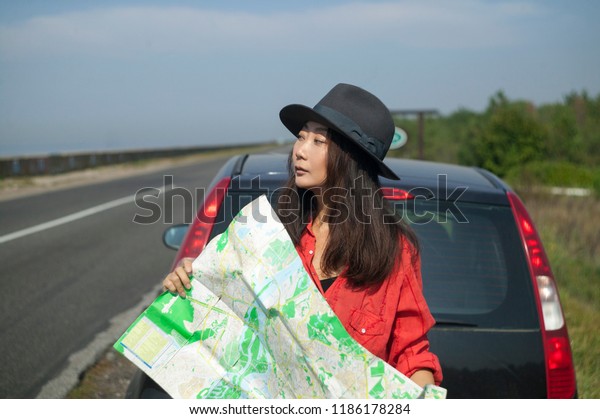 a girl is\
travelling by car with a map 