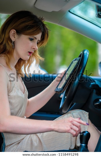 girl\
trying to understand with a book how to drive a\
car