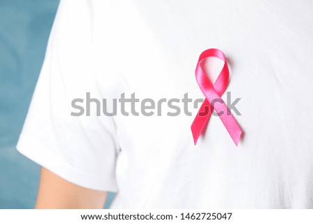 Girl in t-shirt with awareness ribbon against blue background