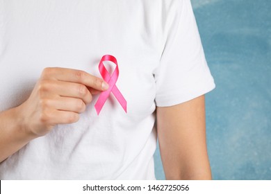 Girl in t-shirt hold awareness ribbon against blue background - Shutterstock ID 1462725056
