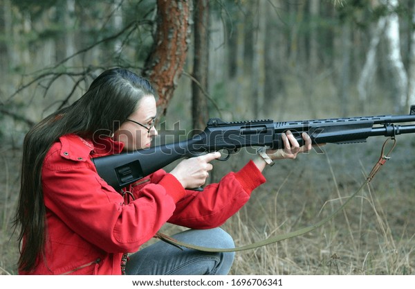 Girl with Turkish 12-gauge rifle Hatsan Escort MP(pump action shotgun). Unformal shooting range near Kiev. April 7, 2020. Kiev Region, Ukraine