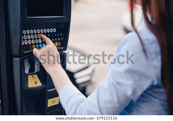 girl types text with her hands\
for making out ticket for parking machine and payment for travel.\
Concept of new technologies in road transport and toll\
roads.