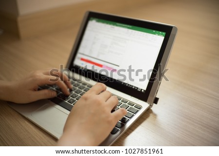 A girl is typing on her laptop by using Microsoft excel program.