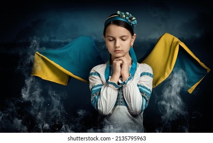 A girl from Ukraine is praying for her country. The girl has wings that are created from the flag of Ukraine. There is a war going on. - Powered by Shutterstock