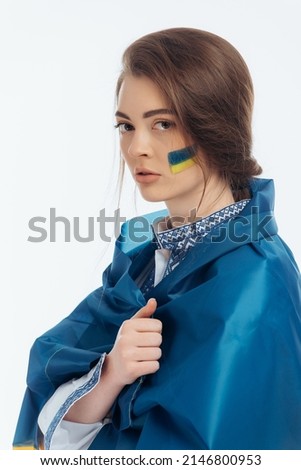 A girl in Ukrainian vyshyvanka holds a flag. War in Ukraine. on a white background