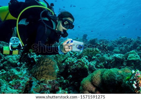 Girl with Underwater Photo Housing Scuba Diving on colorful Reef