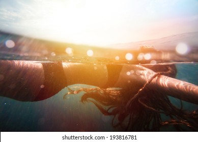 Girl underwater with sun rays. vintage retro style with soft focus, bokeh and sun flare
