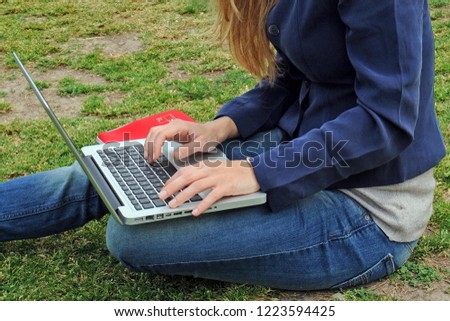 Girl use  her laptop computer with wi-fire ( wi-fi ) internet outdoor in a park -  Smart working during n-cov19 coronavirus