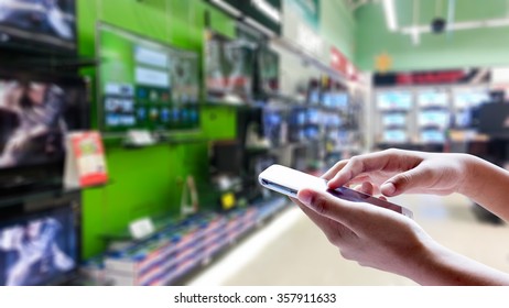 Girl use mobile phone, blur image of supermarket as background. - Shutterstock ID 357911633