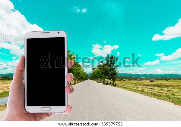 Girl use mobile\
phone, the road as\
background.