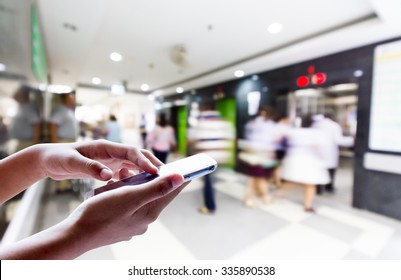 Girl Use Smart Phone , Blur Image Of The Halls In The Hospital Is Background.