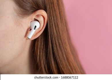 girl uses wireless white headphones on a pink background. Air Pods Pro. with Wireless Charging Case. New Airpods pro on pink background. Airpodspro. female headphones. apple headphones.EarPods
