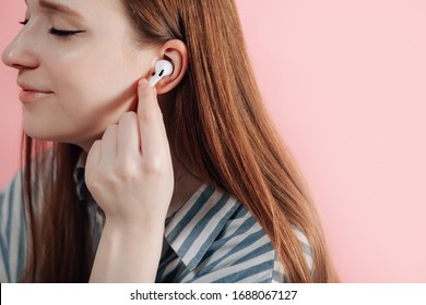 girl uses wireless white headphones on a pink background. Air Pods Pro. EarPods New Airpods pro on pink background. Airpodspro. female headphones.EarPods