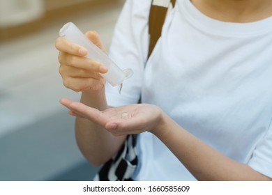 Ein Mädchen, das Alkoholgel verwendet, um Hände zu putzen und die COVID-19 zu schützen