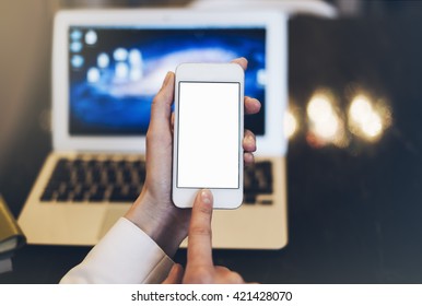 Girl using finger white smartphone and use open laptop with empty blank monitor screen and a cup of coffee or tea on a background bokeh of light in the cafe, digital computer and phone, female hands - Shutterstock ID 421428070