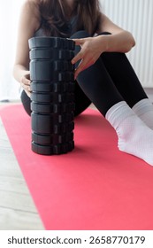 girl using foam roller while doing yoga at home