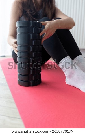 girl using foam roller while doing yoga at home