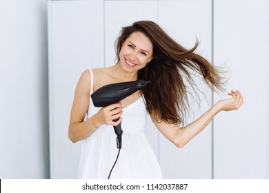 Girl using hair dryer in the Morning, on a white background