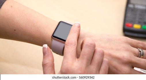 Girl Using Her IWatch. Close Up Of A Finger About To Swipe Across A Smartwatch.
