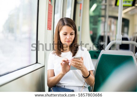 Girl using her smartphone in public transport
