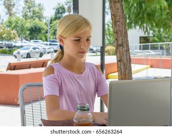 Girl using internet computer at outdoor cafe