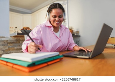 Girl using laptop computer from home while working at university project - Soft focus on face - Powered by Shutterstock