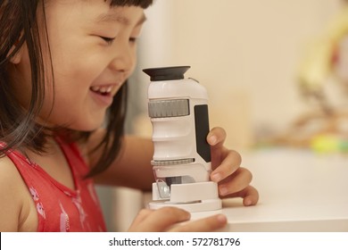 Girl Using Microscope At Home Or Classroom. Curiosity Is The Key Of Successful Learning Experience In Early Childhood Education.