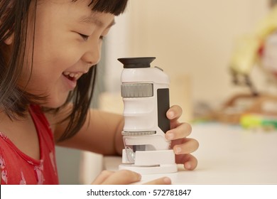 Girl Using Microscope At Home Or Classroom. Curiosity Is The Key Of Successful Learning Experience In Early Childhood Education.