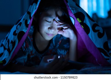 Girl Using Mobile Phone On Dark Bed In The Bedroom, Eye Strain Tension Or Blurry Vision Problem Concept