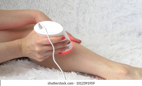 girl using a photoepilator for a hair removal procedure at home - 2