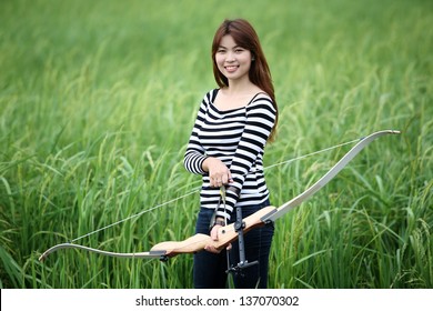 Girl Using Recurve Bow In Paddy Field.