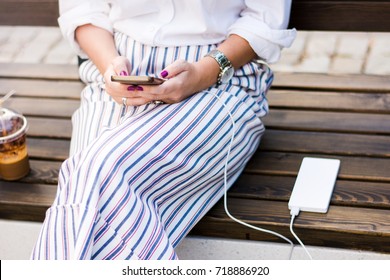 Girl using smart phone while charging on the power bank