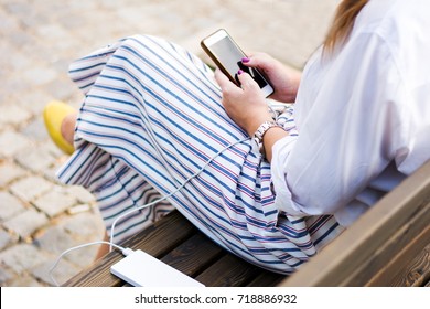 Girl Using Smart Phone While Charging On The Power Bank