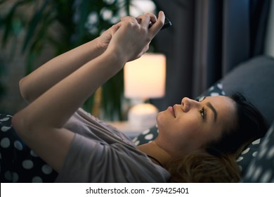 Girl using smart phone while lying down in bed early in the morning - Shutterstock ID 759425401