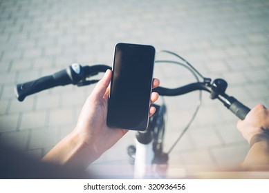 Girl using smartphone and bicycle for traveling in the city