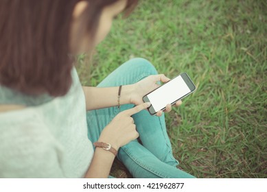 girl using smartphone outdoors.  vintage tone
