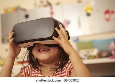 Girl Using Virtual Reality Headset At Home Or In A Classroom.