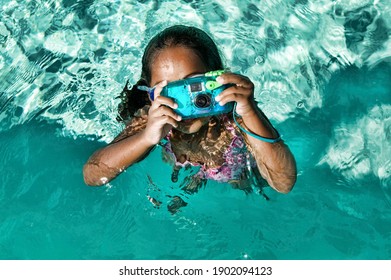 Girl Using Waterproof Camera In Swimming Pool