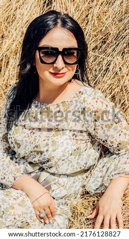 A girl, a vase of haystacks in a colored dress.