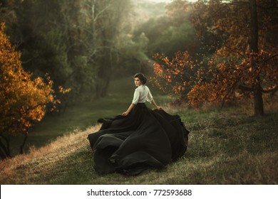 girl in vintage dress running looking around silk skirt train fabric waving flying fluttering wind. Artistic Photography. Vintage clothes medieval woman queen, mysterious lady back. Autumn tree forest - Shutterstock ID 772593688