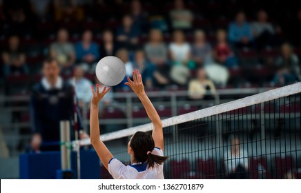 Girl Volleyball player and setter setting the ball for a spiker during a game