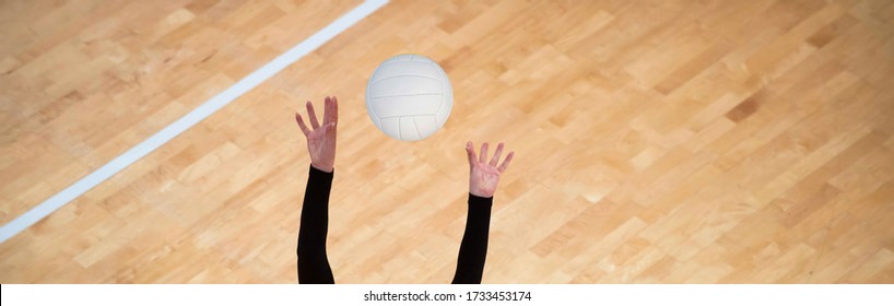 Girl Volleyball player and setter setting the ball for a spiker during a game